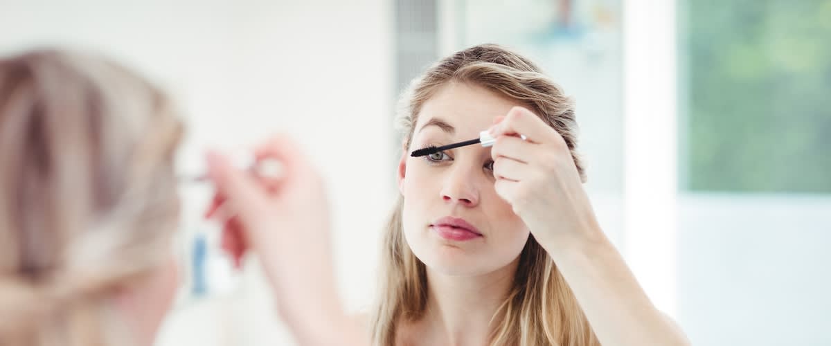 žena maľujúca sa pred zrkadlom