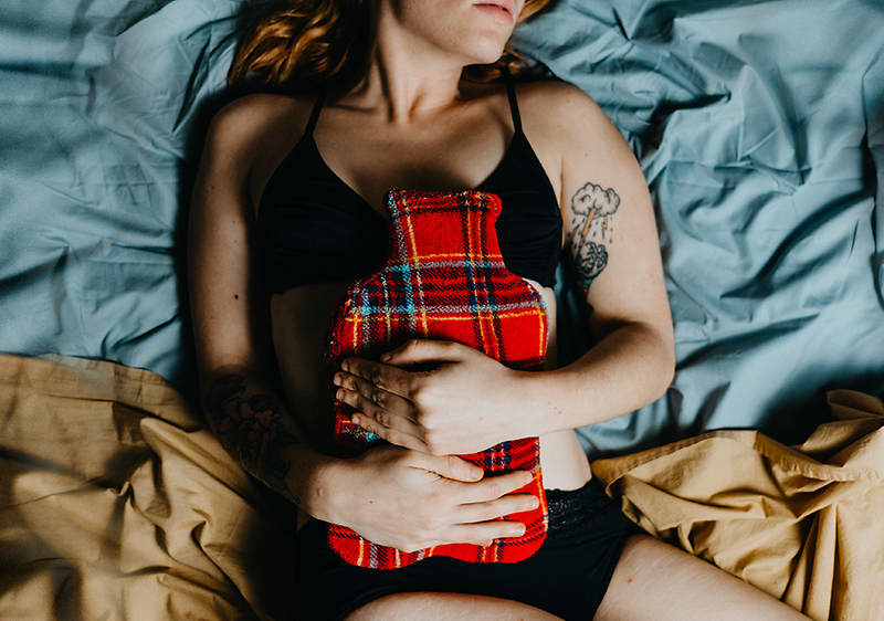 žena leží s bolesťou