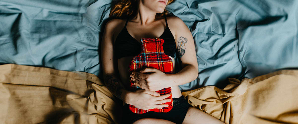 žena leží s bolesťou