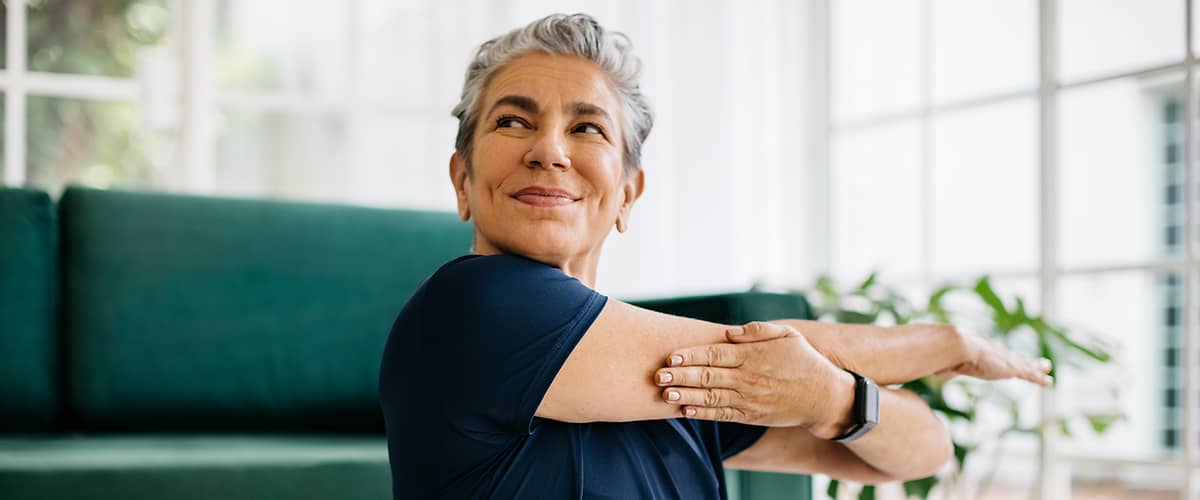 Žena pri strečingu v obývačke.