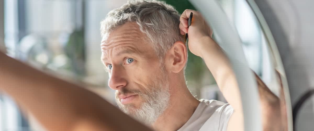 muž si češe vlasy