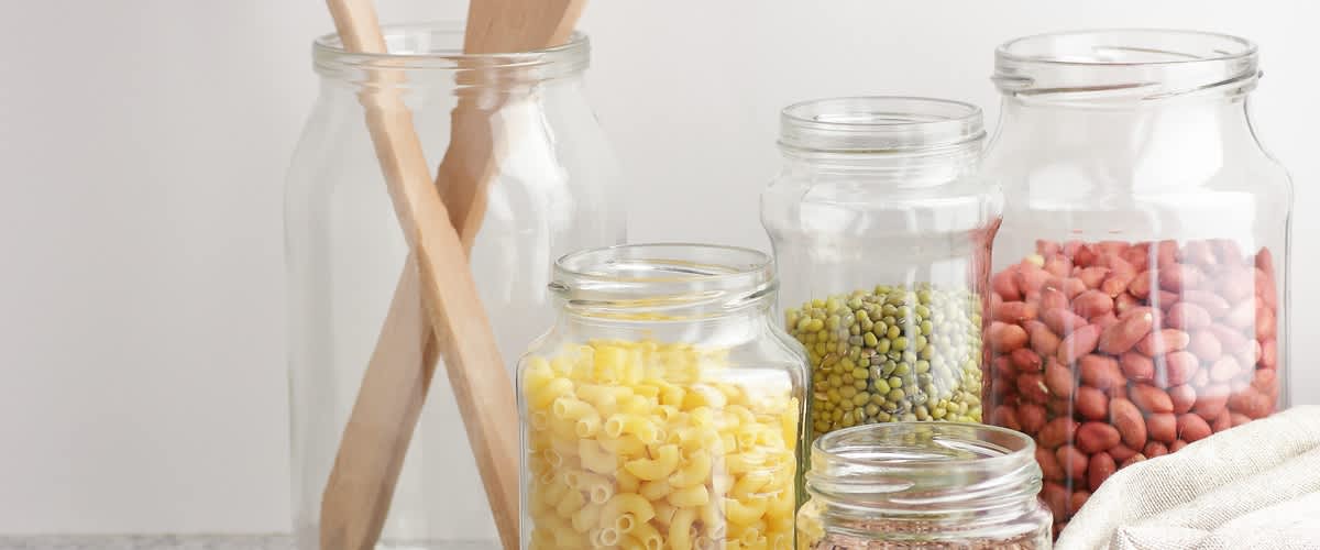 sklenené nádoby naplnené strukovinami a cestovinami