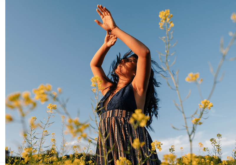 žena v šatách stojí na lúke