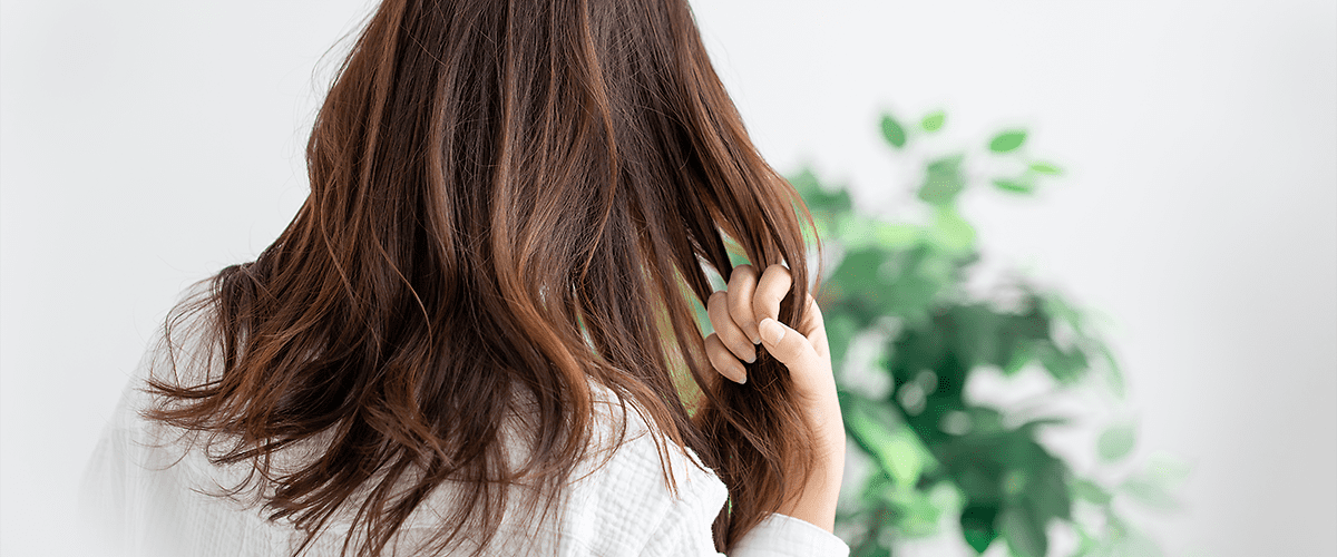 žena má ruku vo svojich dlhých vlasoch