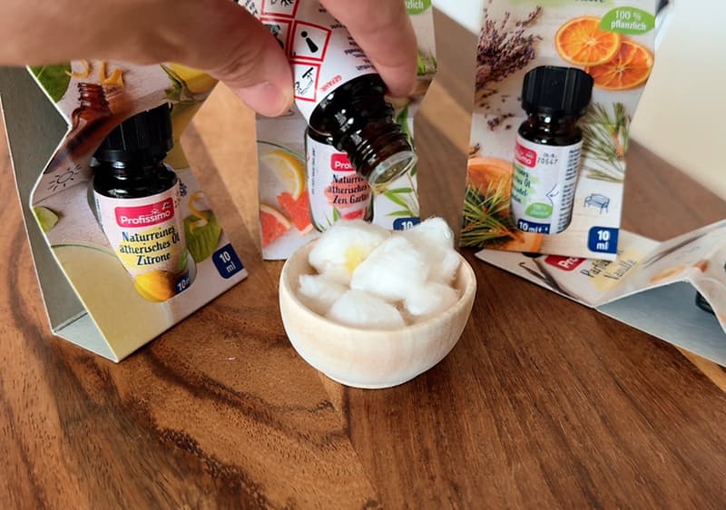 kvapkanie éterického oleja na vatové guličky v miske