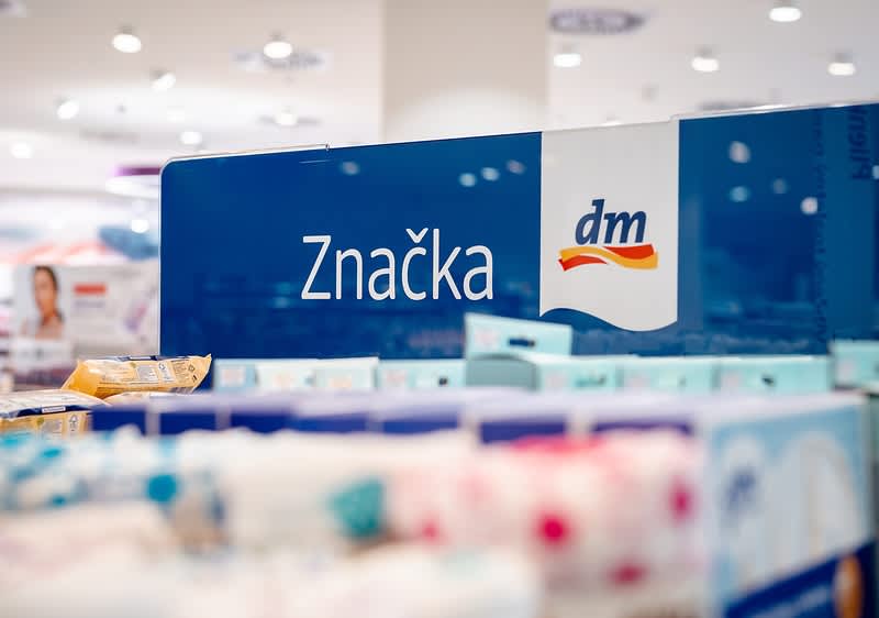 Tabula s textom "Značka dm" nad regálom v predajni dm 