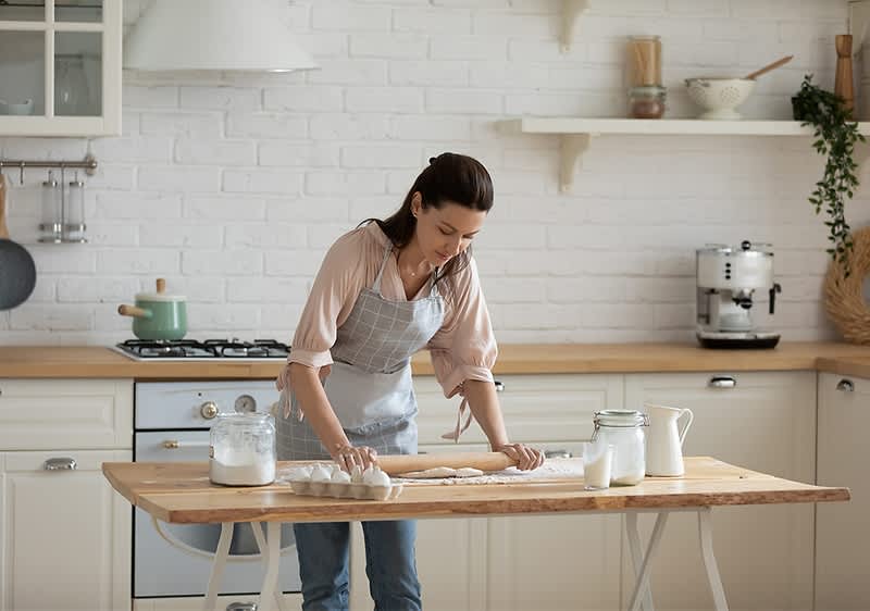 žena v zástere vaľká cesto