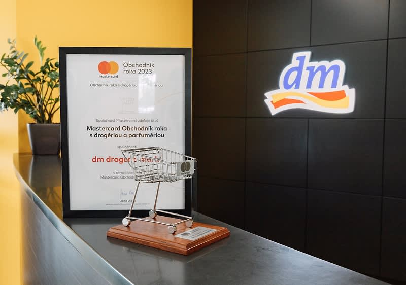 Zarámované ocenenie Mastercard Obchodník roka na recepčnom pulte spoločnosti dm drogerie markt