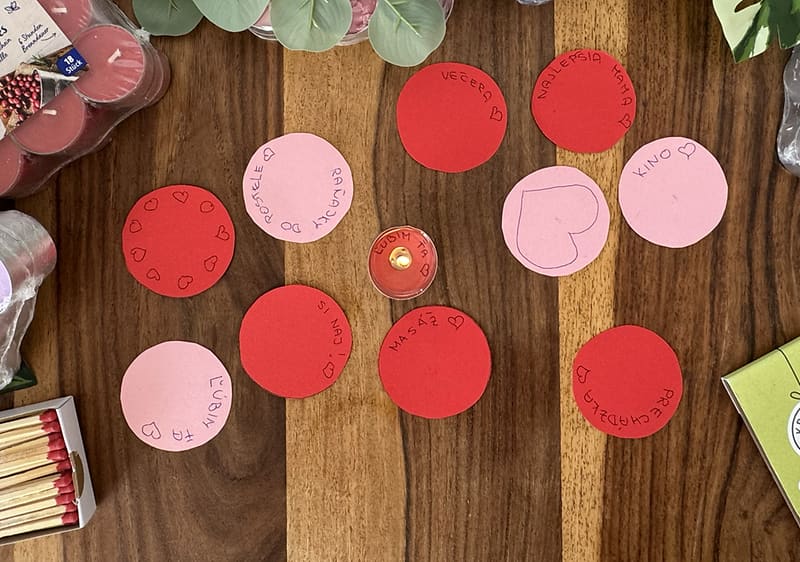 na drevenom stole položené čajové sviečky, odkazy na kruhoch papiera a zápalky