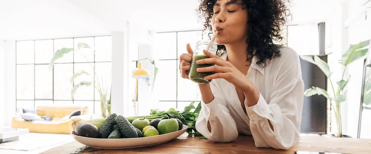 Žena v kuchyni popíjajúca zdravý nápoj.