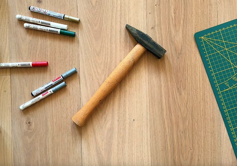 Kladivo a fixky položené na stole