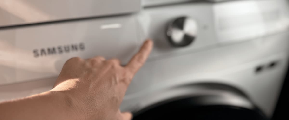 Ruka nastavuje ovládací panel práčky Samsung