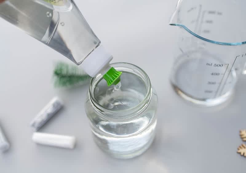 Pohár na snehovú guľu naplnený destilovanou vodou a saponátom