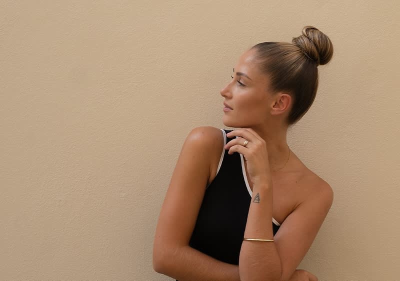Žena s upravenými vlasmi v štýle sleek bun