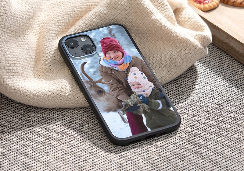 Dieťa v zimnom oblečení s jeleňom na obale telefónu