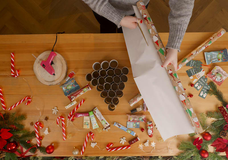 Rolky toaletného papiera na stole a strihanie baliaceho papiera