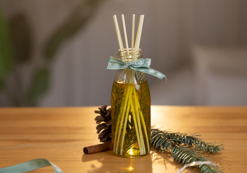 Difuzér v sklenenej fľaši s ihličím a mašľou