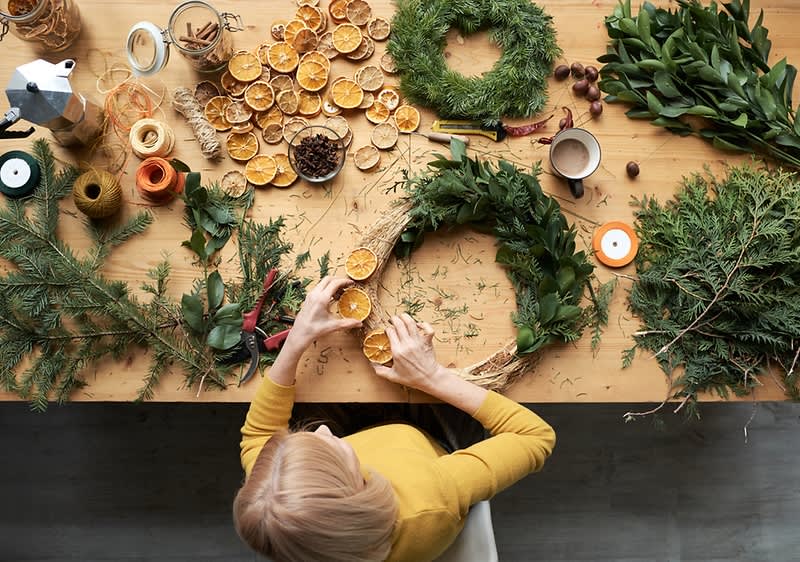 Žena pri výrobe venca z vetvičiek