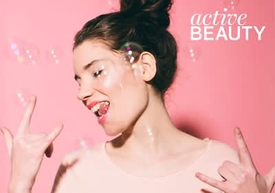 Žena s drdolom na ružovom pozadí s bublinami