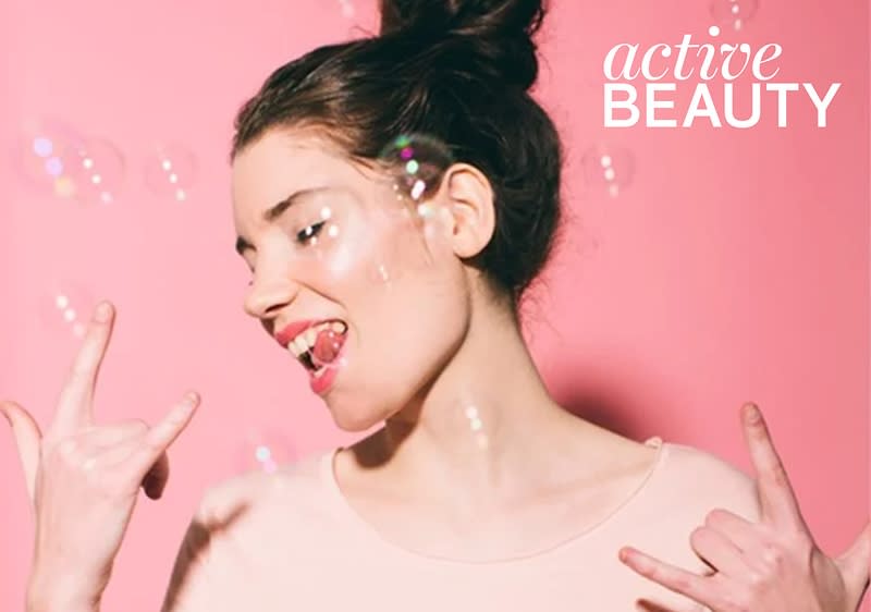 Žena s drdolom na ružovom pozadí s bublinami