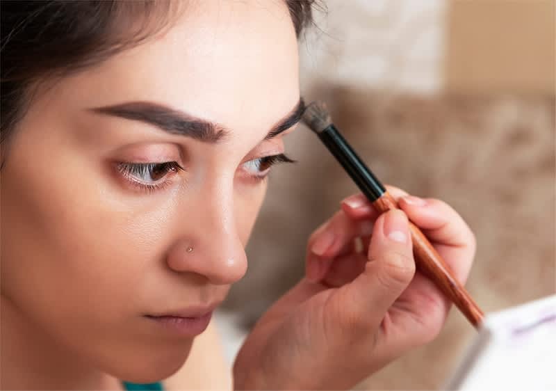 Žena držiaca štetec na líčenie