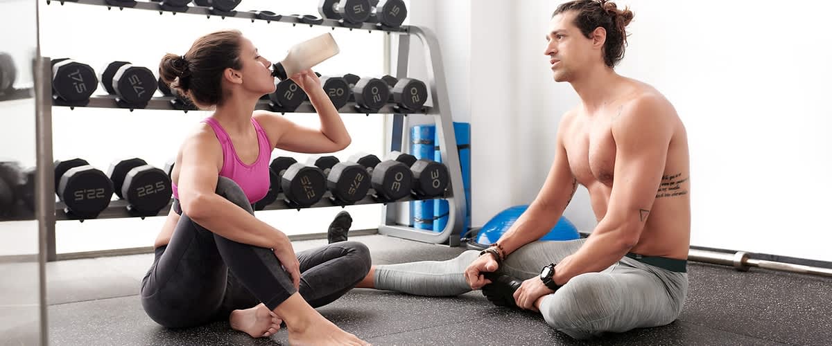 Žena pijúca proteínový shake zo športovej fľaše