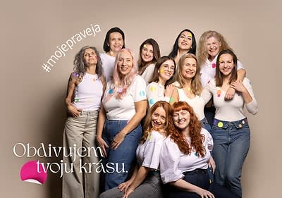 Skupina žien v bielych tričkách pózuje pred kamerou