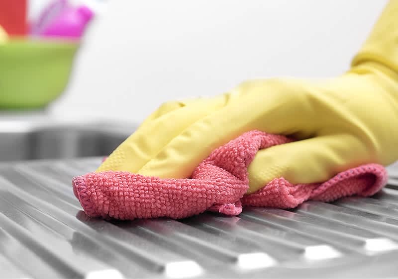 Čistenie kuchynského drezu handričkou 