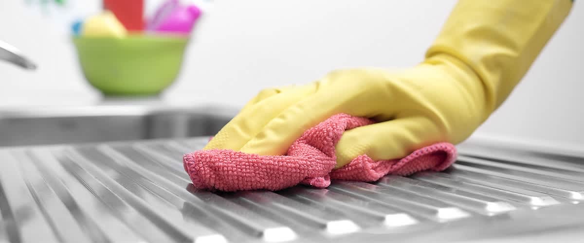 Čistenie kuchynského drezu handričkou 