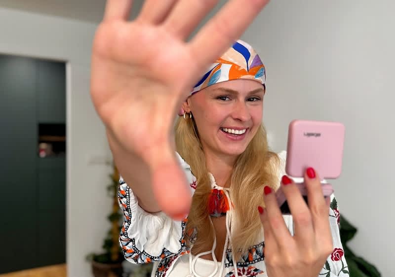 Žena chystajúca sa na festival so zrkadielkom v ruke