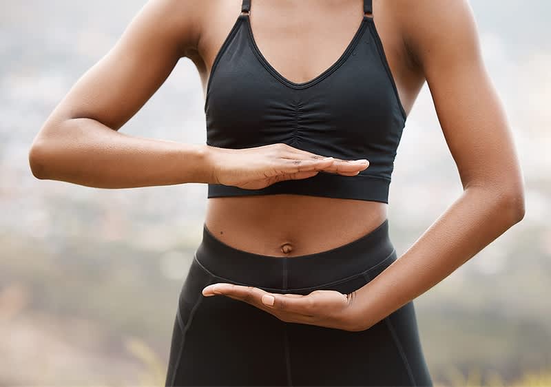 Yoga-Pose mit Händen vor Jogová pozícia s rukami pred bruchom v športovom oblečeníBauch in Sportkleidung