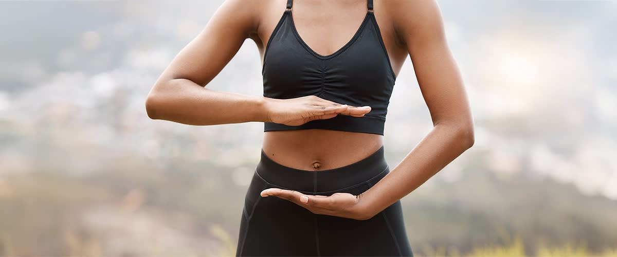 Yoga-Pose mit Händen vor Jogová pozícia s rukami pred bruchom v športovom oblečeníBauch in Sportkleidung
