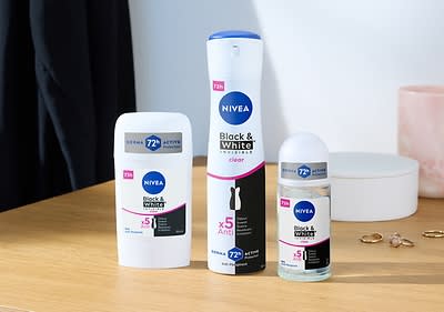 Tri produkty Nivea Black & White: tuhý dezodorant, sprej a guľôčkový dezodorant na stole