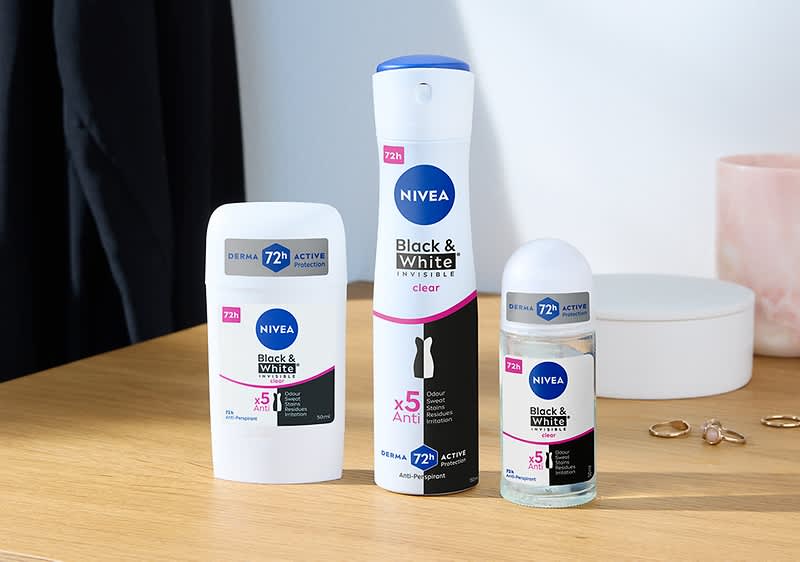 Tri produkty Nivea Black & White: tuhý dezodorant, sprej a guľôčkový dezodorant na stole