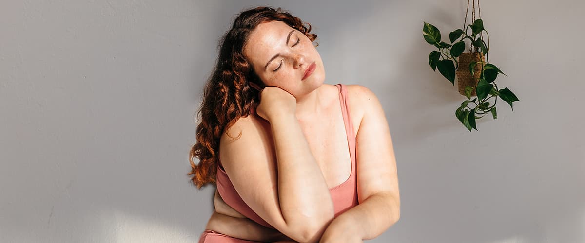 Matka v ružovom tielku podopierajúca si hlavu rukou