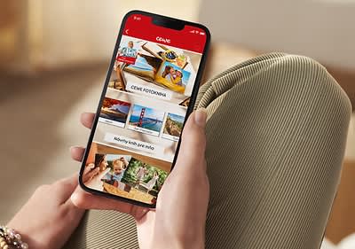 Osoba drží mobil s ponukou zobrazujúcou CEWE fotoslužby