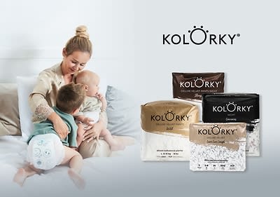 Matka s deťmi na posteli, balenia plienok Kolorky na bielej ploche