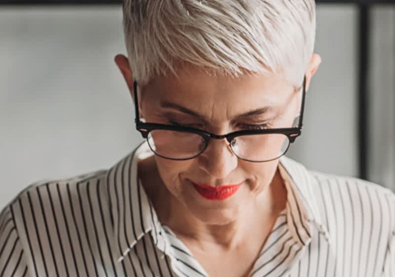 Žena so sivými vlasmi a okuliarmi