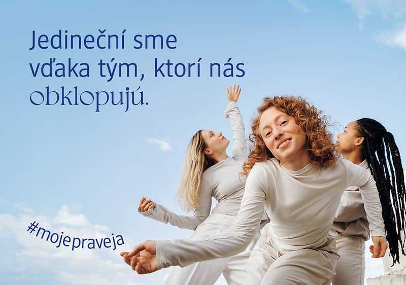 Tri tancujúce ženy v bielom oblečení na modrom pozadí s textom o jedinečnosti