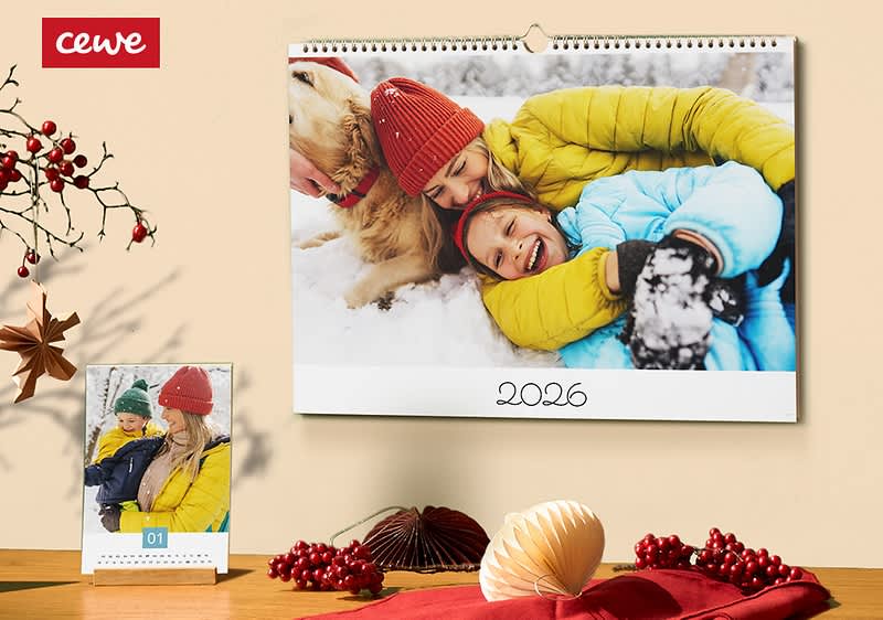 Rodinná fotka na nástennom kalendári, vedľa stolový kalendár, vianočná dekorácia na stole