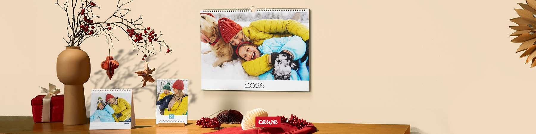 Rodinná fotka na nástennom kalendári, vedľa stolový kalendár, vianočná dekorácia na stole