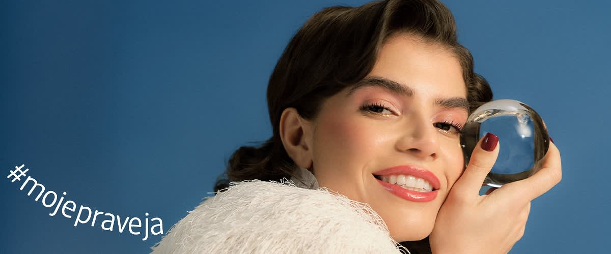 Osoba v bielom oblečení na modrom pozadí s rozmazanou tvárou