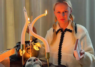 Žena zapaľujúca sviečky v tvare duchov