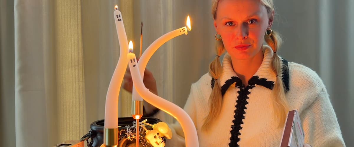 Žena zapaľujúca sviečky v tvare duchov