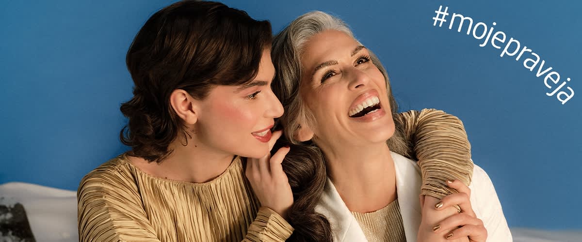 Dve osoby v béžovom oblečení na modrom pozadí s hashtagom v rohu obrázka