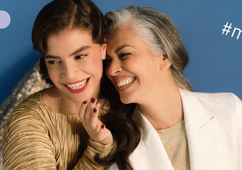 Dve osoby v elegantnom oblečení na modrom pozadí s hashtagom.