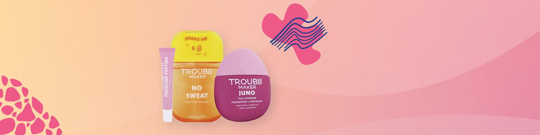 Kozmetické produkty: sprej, korektor a krém značky trouble maker na ružovom pozadí s dekoratívnym prvkom