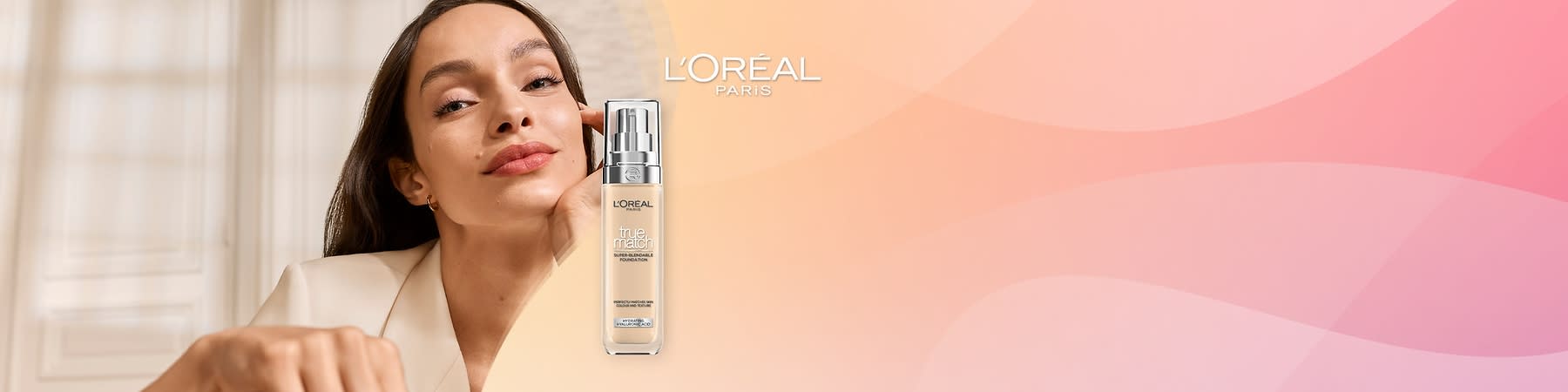 Reklamný obrázok s fľaštičkou podkladového make-upu L'Oréal Paris a čiastočným portrétom ženy na ružovom pozadí