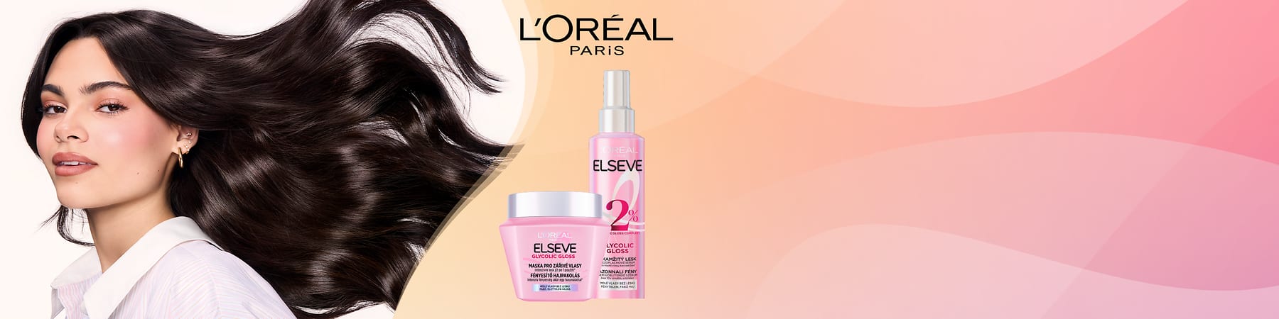 Žena s tmavými vlasmi a náušnicami vedľa ružových kozmetických výrobkov L'Oréal Elseve na ružovom pozadí