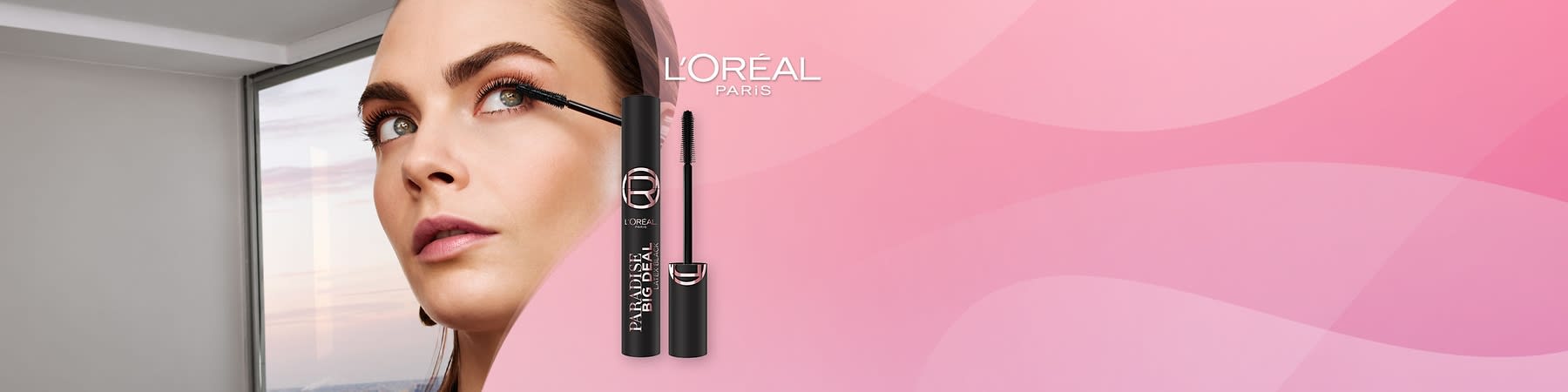 Žena aplikujúca riasenku s obalom výrobku L'Oréal Paradise Big Deal na ružovom pozadí